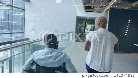 Walking coworkers moving atrium, woman in white top guiding man in wheelchair with AR overlays Walking coworkers moving atrium, woman in white top guiding man in wheelchair with AR overlays 141074885