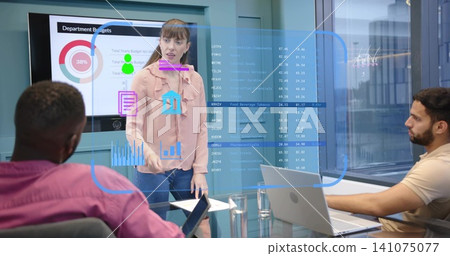 Presenting woman in light pink blouse and jeans gesturing at AR overlay in glass conference room Presenting woman in light pink blouse and jeans gesturing at AR overlay in glass conference room 141075077