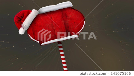 Showing red wooden signboard with white trim and Santa hat in studio, striped pole, golden sparkles Showing red wooden signboard with white trim and Santa hat in studio, striped pole, golden sparkles 141075166
