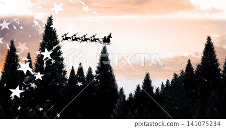 Framing dense evergreen treetops forming dark silhouette at dusk, with sleigh reindeer star overlay 141075234