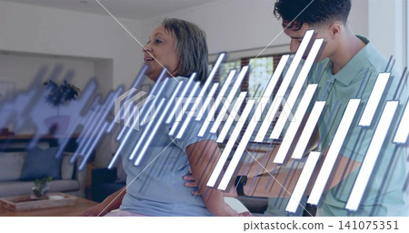 Helping man supporting senior woman wearing light blue shirt on sofa in living room, data overlay Helping man supporting senior woman wearing light blue shirt on sofa in living room, data overlay 141075351