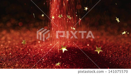 Falling red particle column streaming over glitter mound in studio close-up, with gold stars 141075570