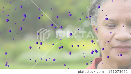 Looking mature woman wearing red-orange top, showing purple dots in garden, copy space Looking mature woman wearing red-orange top, showing purple dots in garden, copy space 141075651