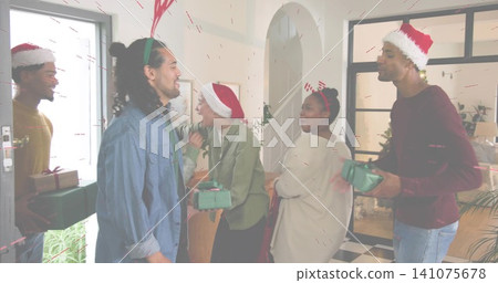 Gathering group of six adults exchanging green gifts and greeting in entryway, with Santa hats Gathering group of six adults exchanging green gifts and greeting in entryway, with Santa hats 141075678