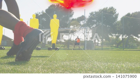 Planting player's cleats on wet grass with red socks yellow mannequins goal orange bib, copy space Planting player's cleats on wet grass with red socks yellow mannequins goal orange bib, copy space 141075900