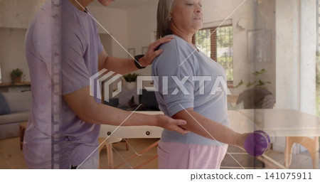 Helping senior woman in blue top and pink pants holding purple ball at home, man supporting Helping senior woman in blue top and pink pants holding purple ball at home, man supporting 141075911