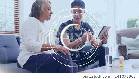 Showing nurse in scrubs guiding senior in white sweater at home with tablet and pill bottles Showing nurse in scrubs guiding senior in white sweater at home with tablet and pill bottles 141075965