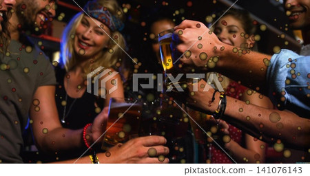 Clinking friends wearing patterned headband and denim shirt at bar, holding beer mugs and bracelets Clinking friends wearing patterned headband and denim shirt at bar, holding beer mugs and bracelets 141076143