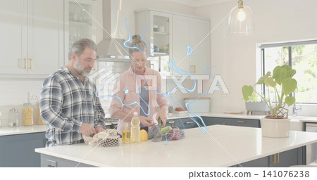 Unpacking couple placing groceries on white kitchen island, with mesh produce bags, lemons, oil Unpacking couple placing groceries on white kitchen island, with mesh produce bags, lemons, oil 141076238