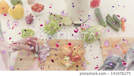 Slicing two hands in light sleeves, plaid, chopping carrots and onion on counter with confetti Slicing two hands in light sleeves, plaid, chopping carrots and onion on counter with confetti 141076275