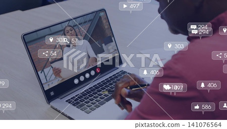 Watching senior in maroon shirt working on laptop with pen and docs at office, notification bubbles Watching senior in maroon shirt working on laptop with pen and docs at office, notification bubbles 141076564