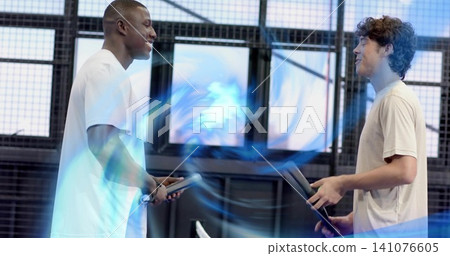 Holding paddles, two men wearing light athletic shirts practicing in gym, with blue light effect Holding paddles, two men wearing light athletic shirts practicing in gym, with blue light effect 141076605
