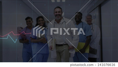 Walking medical staff of five in white coats and scrubs down hospital corridor, with stethoscopes 141076616
