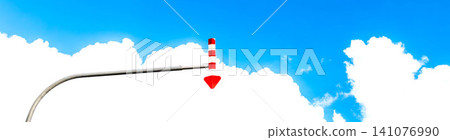 The summer blue sky, rising white clouds, and the distinctive arrow-shaped markings on the roads of a snowy region. 141076990