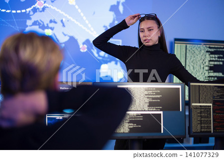 Cybersecurity professionals analyzing real-time threat data in a control room setting Cybersecurity professionals analyzing real-time threat data in a control room setting 141077329
