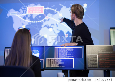 Cybersecurity professionals collaborating on real-time threat monitoring and incident response Cybersecurity professionals collaborating on real-time threat monitoring and incident response 141077331