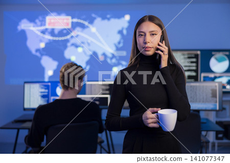 Female cybersecurity analyst working in a SOC with a colleague and data screens Female cybersecurity analyst working in a SOC with a colleague and data screens 141077347
