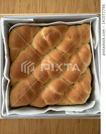 方形模具中盛裝的撕開式鹹味麵包,外皮呈金棕色。 方形模具中盛裝的撕開式鹹味麵包,外皮呈金棕色。 141077798
