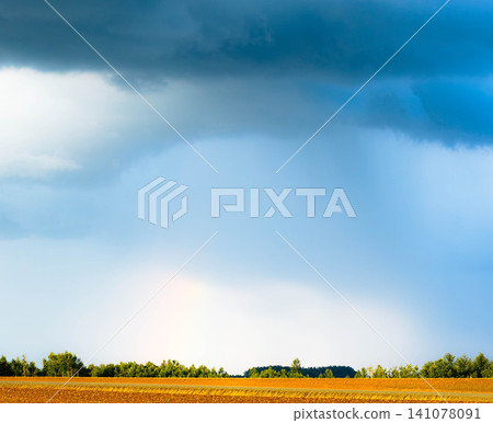 A faint rainbow is visible amidst the cloudy skies of Biei, Hokkaido, a scene marking the end of summer. A faint rainbow is visible amidst the cloudy skies of Biei, Hokkaido, a scene marking the end of summer. 141078091