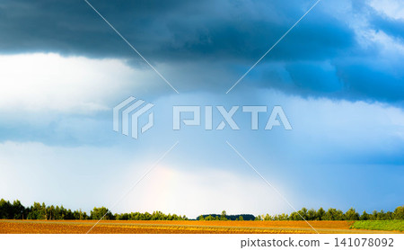 A faint rainbow is visible amidst the cloudy skies of Biei, Hokkaido, a scene marking the end of summer. A faint rainbow is visible amidst the cloudy skies of Biei, Hokkaido, a scene marking the end of summer. 141078092