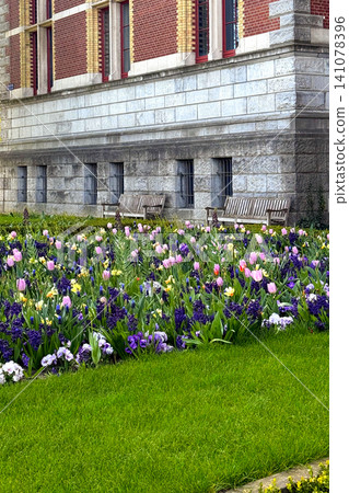 Flower bed and green grass near historical house in Amsterdam the Netherlands Flower bed and green grass near historical house in Amsterdam the Netherlands 141078396