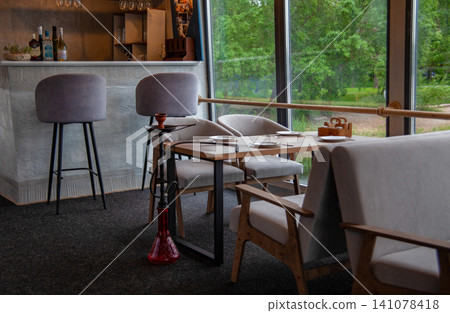 Cosy restaurant with table dishes chairs hookah and bar counter 141078418