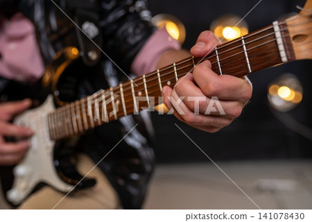 Close up of fingers on electric guitar fretboard Close up of fingers on electric guitar fretboard 141078430