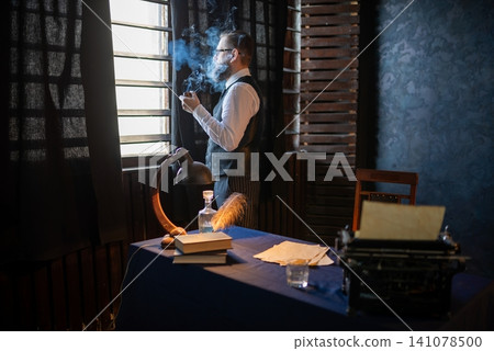 Man in formal vest smoking pipe by a window 141078500