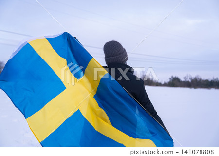 Swedish Patriot Woman With National Flag Of Sweden On White Snow Nature Swedish Patriot Woman With National Flag Of Sweden On White Snow Nature 141078808