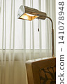 Reading lamp and chair in a hotel room 141078948