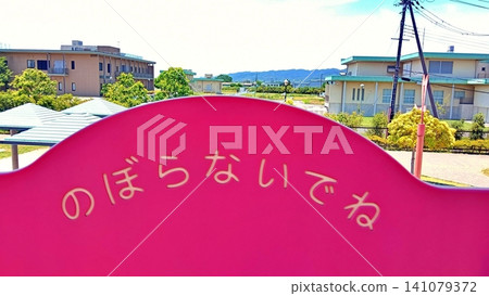遊樂場設施上的警示標誌和初夏的街景。 遊樂場設施上的警示標誌和初夏的街景。 141079372
