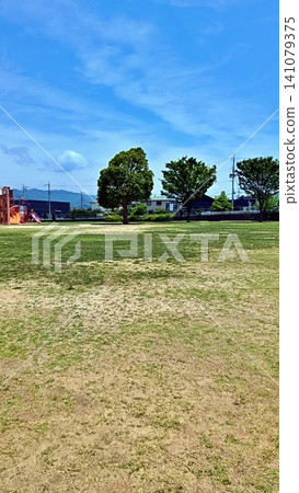 公園裡有一大片草坪,藍天白雲,還有遊樂設施。 公園裡有一大片草坪,藍天白雲,還有遊樂設施。 141079375