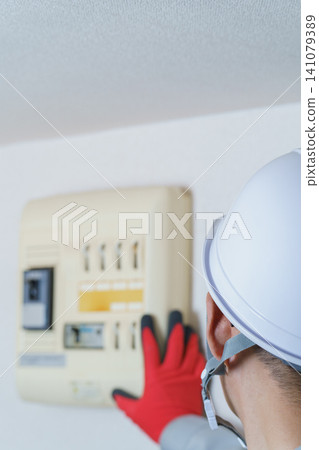 工人在檢查配電盤和斷路器 工人在檢查配電盤和斷路器 141079389