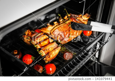 Delicious roasted ribs in oven, closeup. Yummy meat Delicious roasted ribs in oven, closeup. Yummy meat 141079441