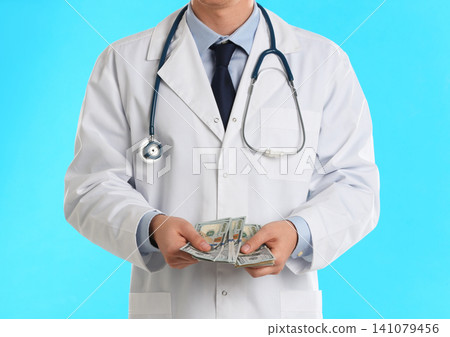 Doctor with bribe on light blue background, closeup. Corruption in medicine 141079456