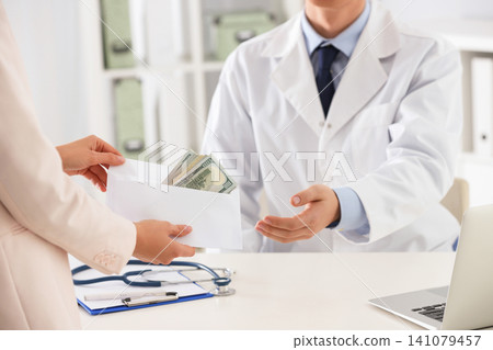 Patient giving bribe to doctor in clinic, closeup. Corrupted medicine Patient giving bribe to doctor in clinic, closeup. Corrupted medicine 141079457