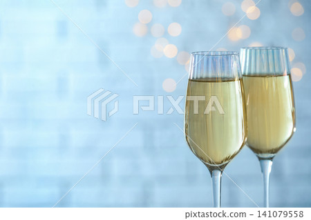 Glasses of champagne against blurred lights. Space for text Glasses of champagne against blurred lights. Space for text 141079558