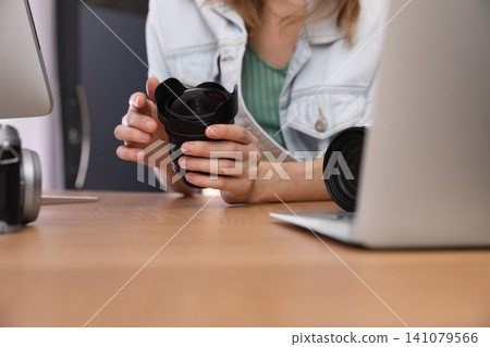 Professional photographer working at table in office, closeup Professional photographer working at table in office, closeup 141079566