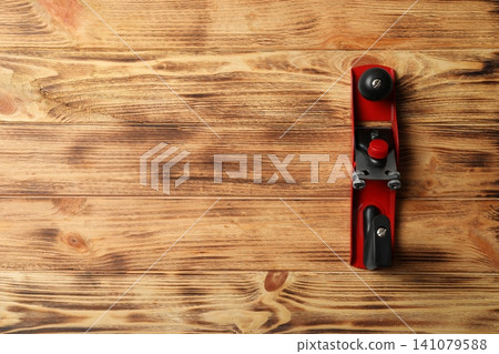 Modern jack plane and space for text on wooden background, top view. Carpenter's tool Modern jack plane and space for text on wooden background, top view. Carpenter's tool 141079588