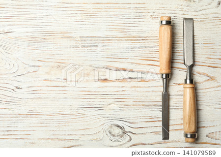 Chisels on white wooden background, flat lay with space for text. Carpenter's tools Chisels on white wooden background, flat lay with space for text. Carpenter's tools 141079589