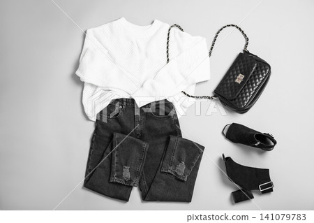 Stylish outfit with jeans on light grey background, flat lay Stylish outfit with jeans on light grey background, flat lay 141079783