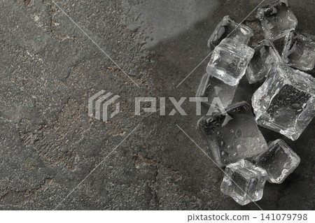Crystal clear ice cubes with water drops on grey table, flat lay. Space for text Crystal clear ice cubes with water drops on grey table, flat lay. Space for text 141079798