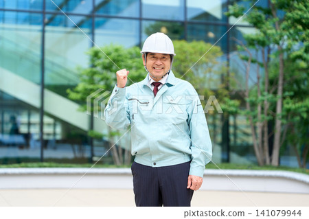 Asian man standing in work clothes Asian man standing in work clothes 141079944