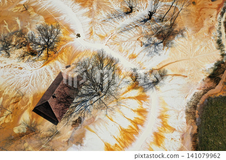 Sinking house in the ghost village of Geamana, Romania, choked of toxic mining residuals, aerial view Sinking house in the ghost village of Geamana, Romania, choked of toxic mining residuals, aerial view 141079962