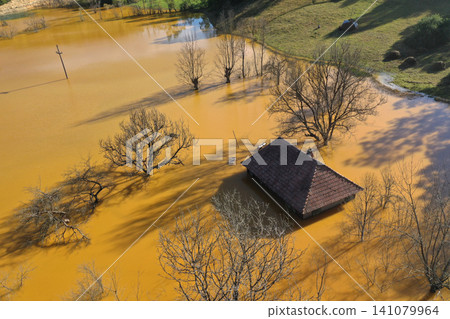 Aerial view choked sinking village house by acid mine drainage toxic waters Aerial view choked sinking village house by acid mine drainage toxic waters 141079964
