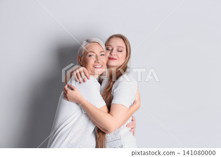 Mother and her adult daughter on white background. Space for text Mother and her adult daughter on white background. Space for text 141080000