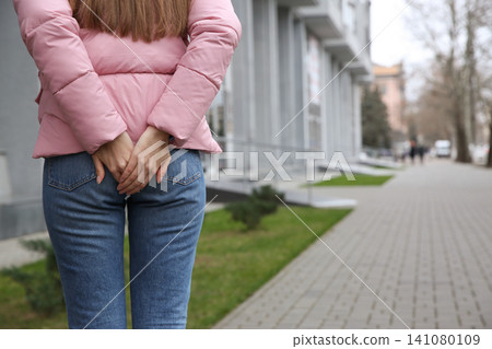 Woman suffering from hemorrhoid pain outdoors, closeup 141080109