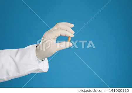 Doctor holding suppository for hemorrhoid treatment on blue background, closeup Doctor holding suppository for hemorrhoid treatment on blue background, closeup 141080110