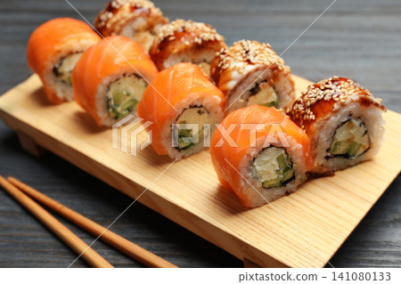 Set of delicious sushi rolls on grey wooden table 141080133