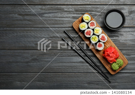 Delicious sushi rolls on grey wooden table, flat lay. Space for text Delicious sushi rolls on grey wooden table, flat lay. Space for text 141080134